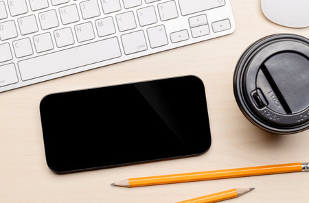 Blank black screen smartphone on a desk, perfect for your design mockupの写真素材