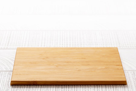 Wooden cutting board on white kitchen table. With copy spaceの写真素材