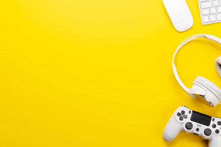 Gaming gear and tech accessories on a yellow background, perfect for gaming and tech-related themes. Flat lay with copy spaceの写真素材