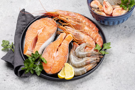 A top view of fresh seafood such as shrimp, langoustines, and trout steaksの写真素材