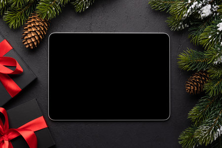 Tablet with blank screen, gift boxes and Christmas decor. Xmas device screen templateの写真素材