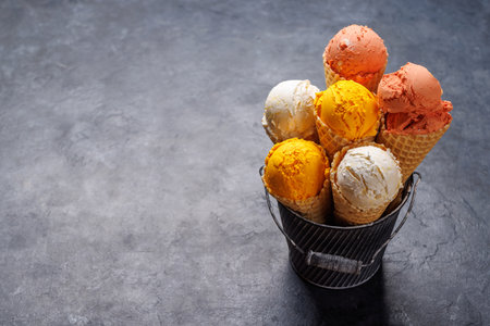 Assorted ice cream flavors in delightful waffle cones, a treat for every taste bud. Over stone background with copy spaceの写真素材