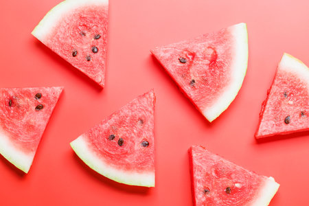 Juicy watermelon slices on a vibrant red background, a refreshing summer treat. flat layの写真素材