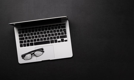 Office desk table with laptop computer and eyeglasses. top view. Flat lay with copy spaceの写真素材
