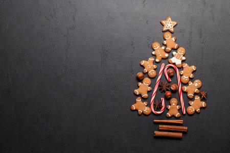 Christmas gingerbread cookies in fir tree shape and space for greetings text. Flat lay