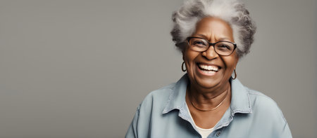 Smiling elderly African woman on plain background with copy spaceの素材