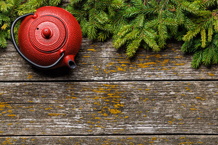 Teapot, cup, and fir tree branches create a cozy scene. Flat lay with copy space. Christmas card templateの写真素材