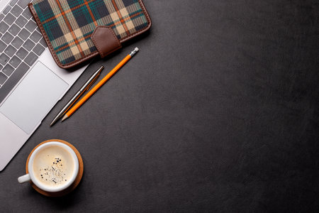 Workplace essentials: Laptop, coffee, notepad and supplies. Flat lay with copy space