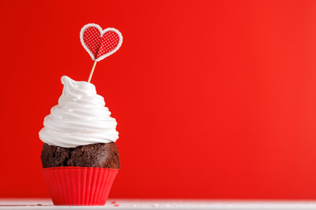 Cupcake love: Heart-themed treats on a vibrant red backdrop with copy space for your Valentines day greetingsの写真素材