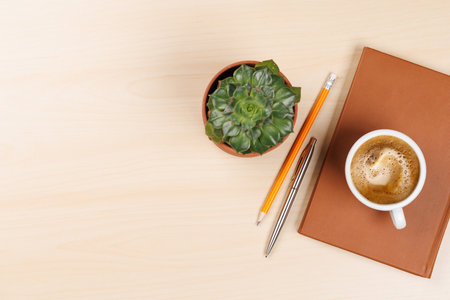 Workplace essentials: Coffee, notepad and supplies. Flat lay with copy space