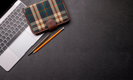 Workplace essentials: Laptop, notepad and supplies. Flat lay with copy spaceの写真素材