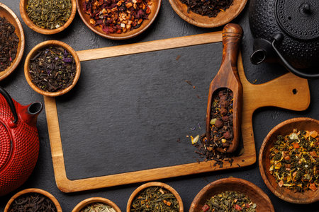 A collection of various teas nestled in wooden bowls. Flat lay with copy spaceの写真素材