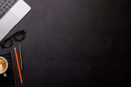 Workplace essentials: Laptop, coffee, notepad and supplies. Flat lay with copy spaceの写真素材