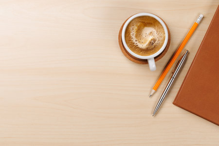 Workplace essentials: Coffee, notepad and supplies. Flat lay with copy spaceの写真素材