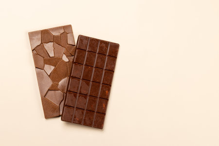 Sweet temptation: Chocolate bars on beige background with copy spaceの写真素材