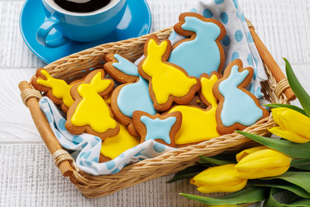 Easter Scene with Bunny-Shaped Gingerbread Cookies, Yellow Tulips, and Coffee Cup