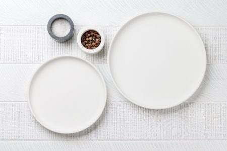 Empty plates on wooden table, overhead view with copy spaceの写真素材