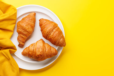 Fresh croissants on plate. Flat lay with copy spaceの写真素材