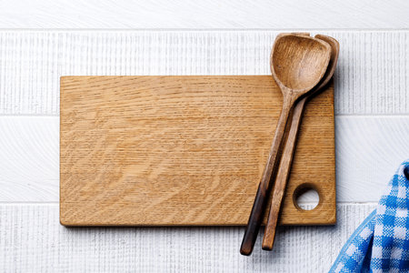 Culinary essentials: Cooking wooden board on wood table table. Flat lay with copy spaceの写真素材