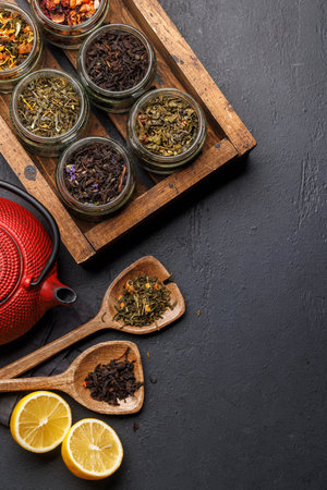 Tea time assortment: Various dry tea leaves and teapot. Flat lay with copy spaceの写真素材