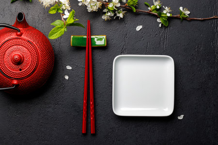 Table adorned with cherry blossom branch and chopsticks, epitomizing Japanese food culture, providing ample copy spaceの写真素材