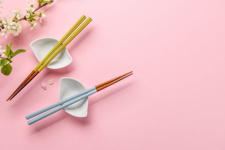 Table adorned with cherry blossom branch and chopsticks, epitomizing Japanese food culture, providing ample copy spaceの写真素材