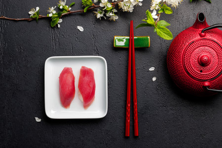 Tuna sushi adorned with cherry blossom branch and chopsticks, epitomizing Japanese food culture, providing ample copy spaceの写真素材