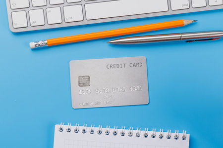 Credit card on office table with laptop and supplies. Flat lay. Banking conceptの写真素材