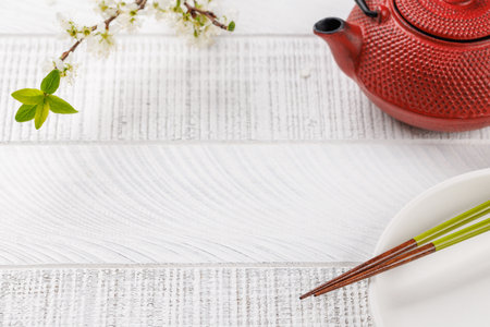 Table adorned with cherry blossom branch and chopsticks, epitomizing Japanese food culture, providing ample copy spaceの写真素材