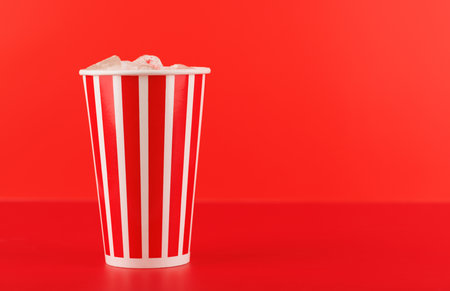 Paper cup with cola and ice over red background, with copy spaceの写真素材