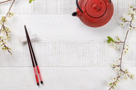 Table adorned with cherry blossom branch and chopsticks, epitomizing Japanese food culture, providing ample copy spaceの写真素材