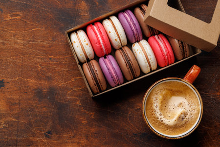 Coffee and colorful macaroons in gift box. Top view with space for textの写真素材