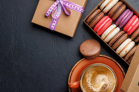 Coffee and colorful macaroons in gift box. Top view with space for textの写真素材