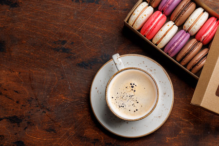 Coffee and colorful macaroons in gift box. Top view with space for textの写真素材