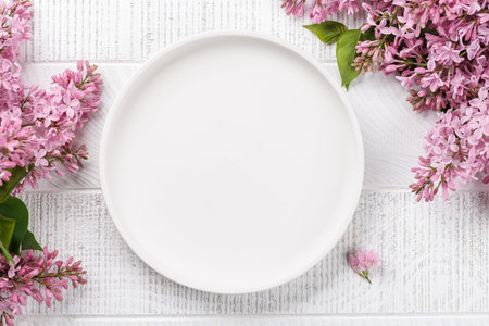 Empty plate on table adorned with blossom branch, providing ample copy spaceの写真素材