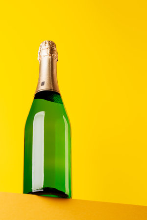 Champagne elegance: Bottle against a vibrant yellow background. With copy spaceの写真素材