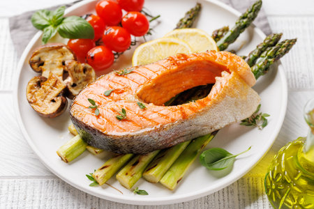 Grilled salmon steak over grilled asparagus, a delicious and healthy mealの写真素材