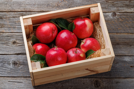 Wooden box with fresh red apples on wood tableの写真素材