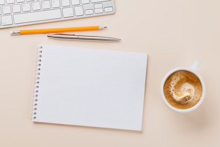 Office desk table with notepad, cup of coffee and supplies. Top view with copy space. Flat layの写真素材
