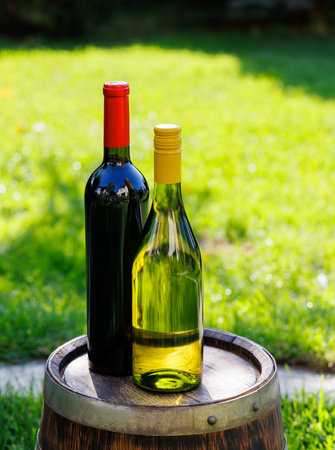 Wine bottles on barrel outdoors with copy spaceの写真素材