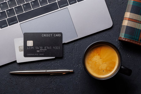 Black credit card on office table with supplies. Flat lay. Premium banking conceptの写真素材