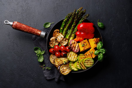 Assorted grilled vegetables on a frying pan, showcasing a colorful and healthy meal. Flat layの写真素材