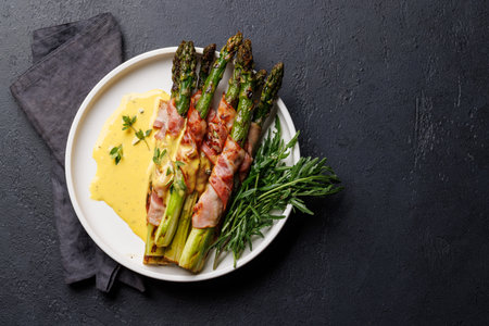 Grilled asparagus with bacon and egg sauce on a plate. Flat lay with copy spaceの写真素材