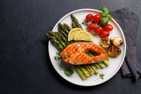 Grilled salmon steak over grilled asparagus, a delicious and healthy meal. With copy spaceの写真素材