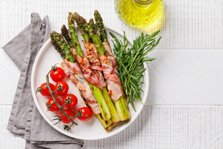 Grilled asparagus with bacon and egg sauce on a plate. Flat lay with copy spaceの写真素材