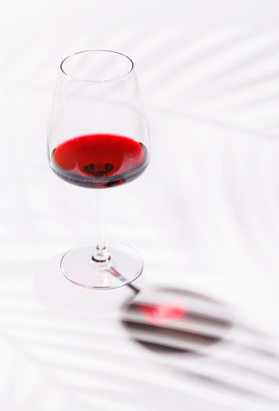 A glass of red wine against a bright and elegant background. Perfect for celebrations or relaxed...