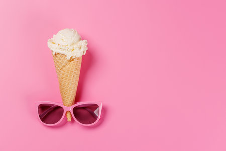 A playful ice cream cone wearing stylish sunglasses, set against a vibrant pink background, radiating summer vibes and funの写真素材