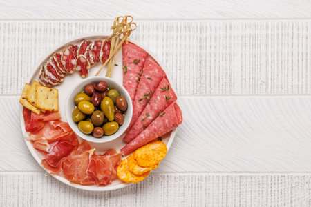 An assortment of various meats arranged on a plate, ideal for an antipasto, featuring a rich mix of flavors and texturesの写真素材