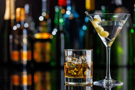 Various cocktails on a bar table. The colorful bokeh of illuminated bottles in the background enhances the mood, creating a dynamic and lively ambianceの写真素材