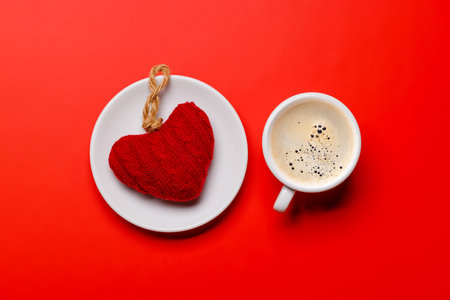 A delightful combination of a steaming coffee cup and a heart-shaped gift, ideal for Valentine's Day moments or romantic gesturesの写真素材